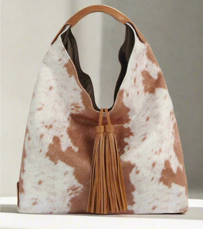 The Faux Suede Cow Print Hobo Tote Bag With Tassels